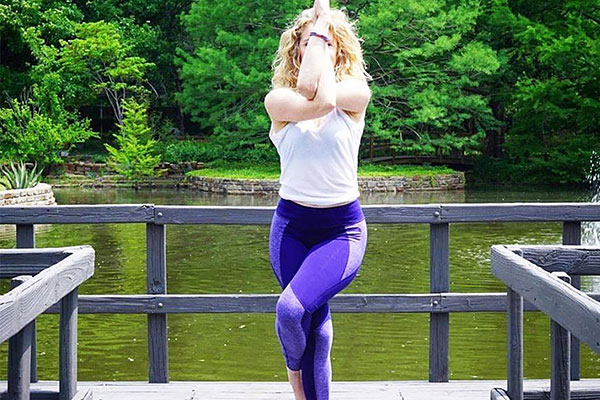 Woman doing Yoga on Lake pier