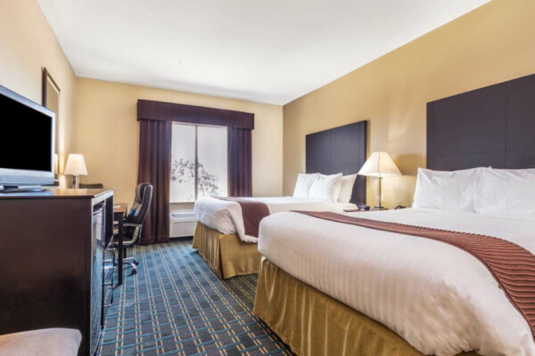 DAYS INN & SUITES hotel room with double beds and dresser