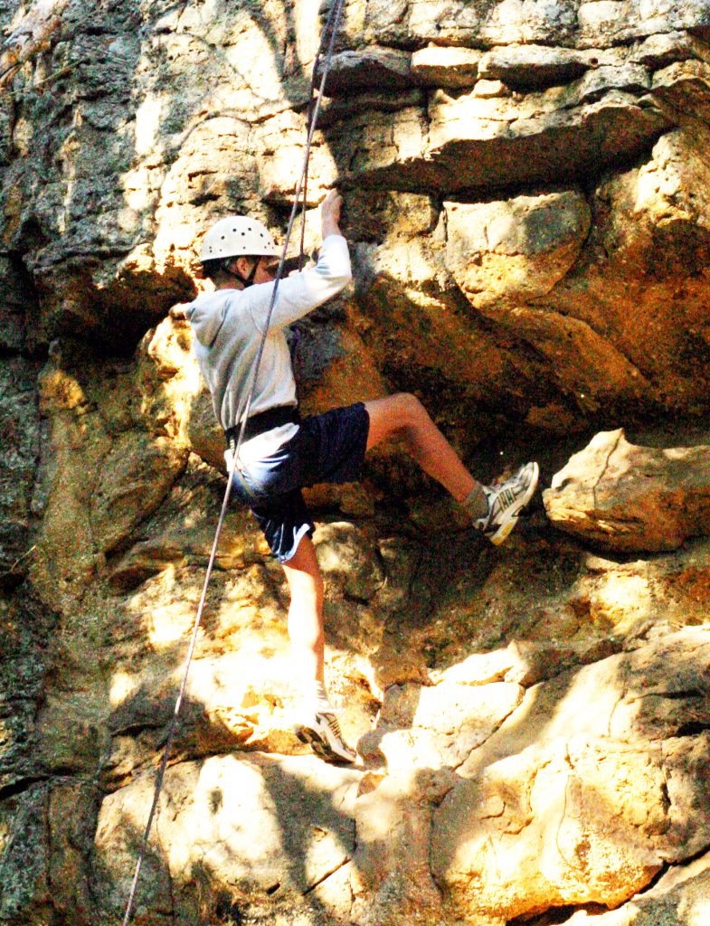 Man climbing wall with ropes