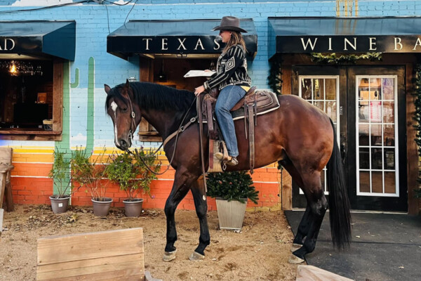 woman riding horse in front of BANKHEAD TEXAS WINE
