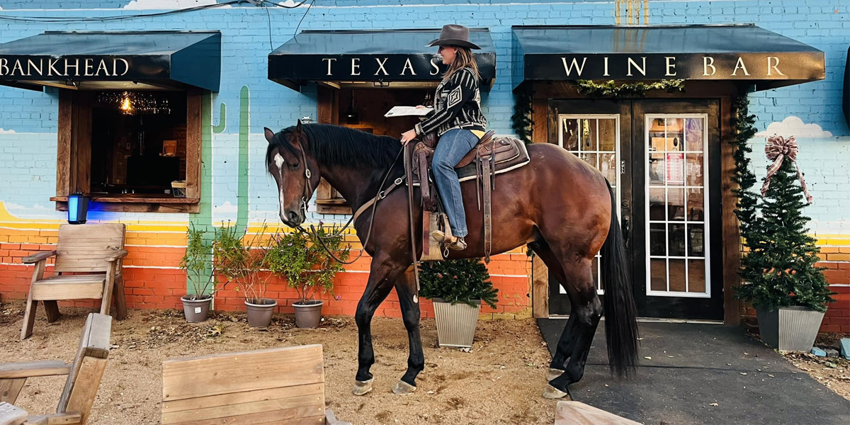 woman riding horse in front of BANKHEAD TEXAS WINE