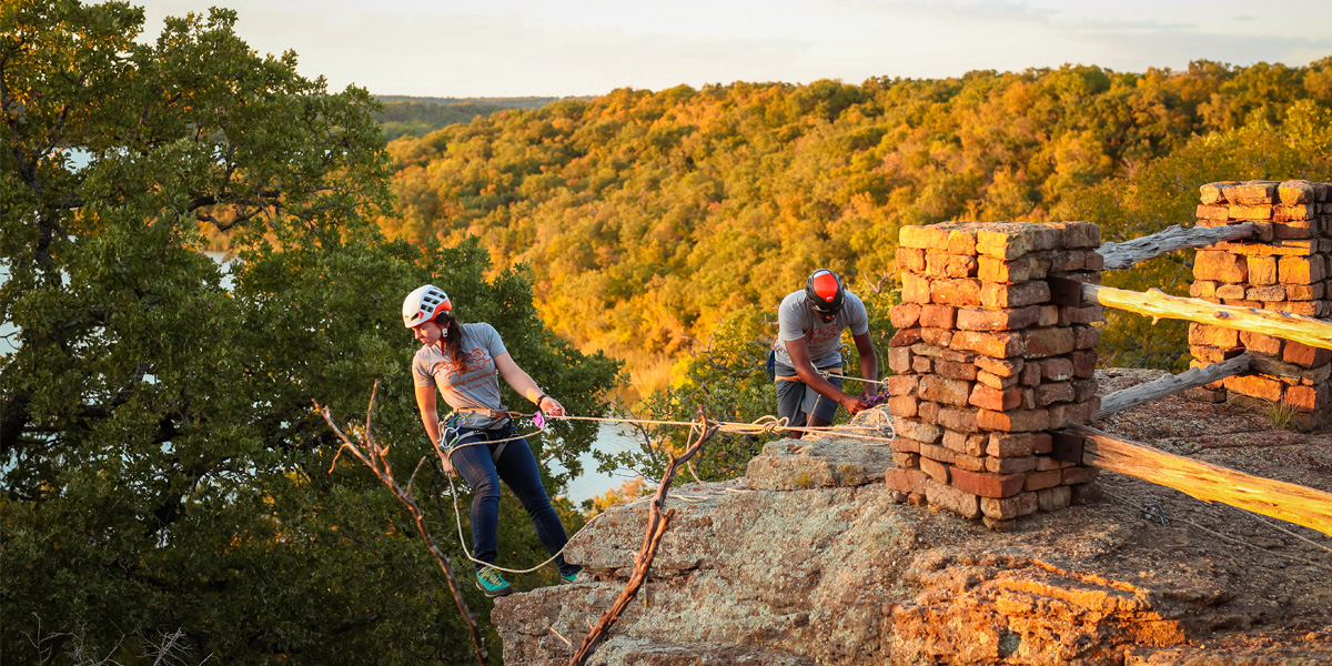 Man and woman rock climbing in Lake Mineral Wells State Park