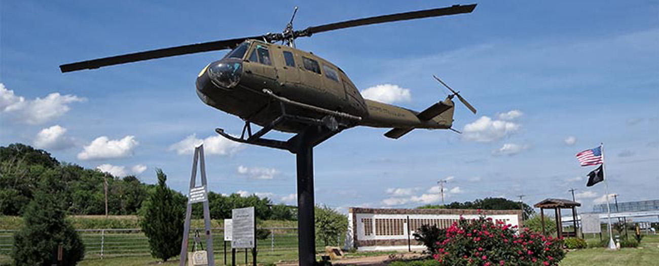 Huey Helicopter in front of memorial wall