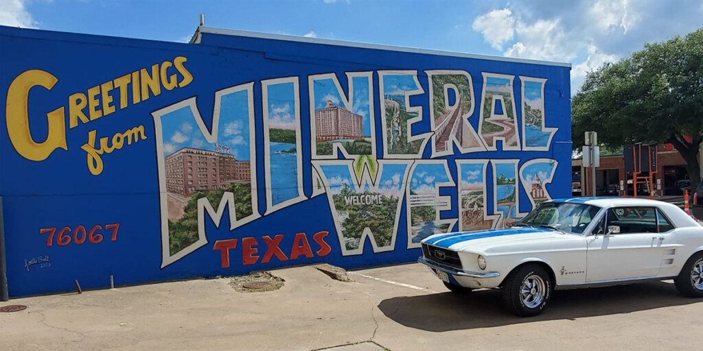 Ford Mustang parked in front of  Mineral Wells Mural