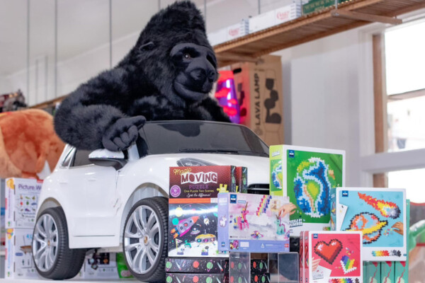Gorilla siting in toy Porsche in a a toy shop
