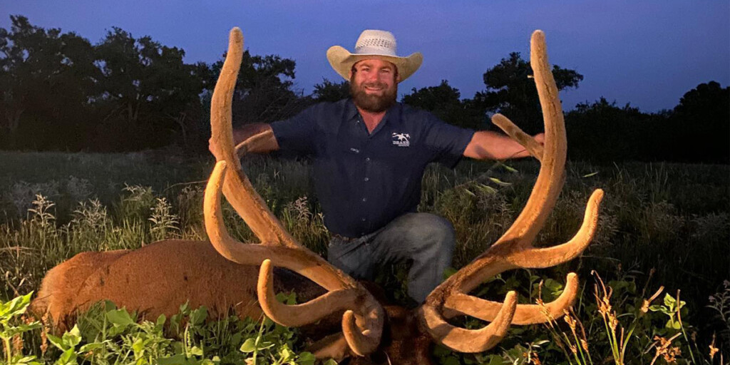 man holding horns of buck