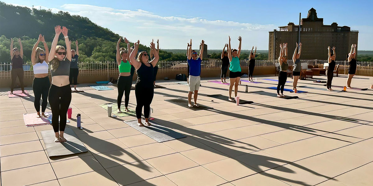Group doing Yoga on Crazy Water Hotel Roof Top